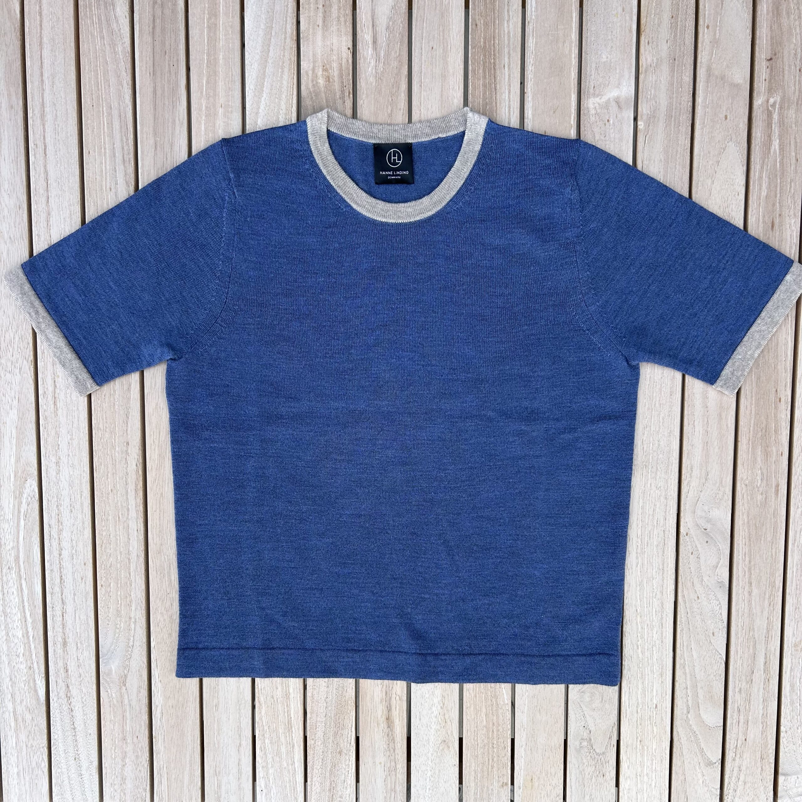 Short-sleeved knit blouse in blue with light beige details from Hanne Linding.