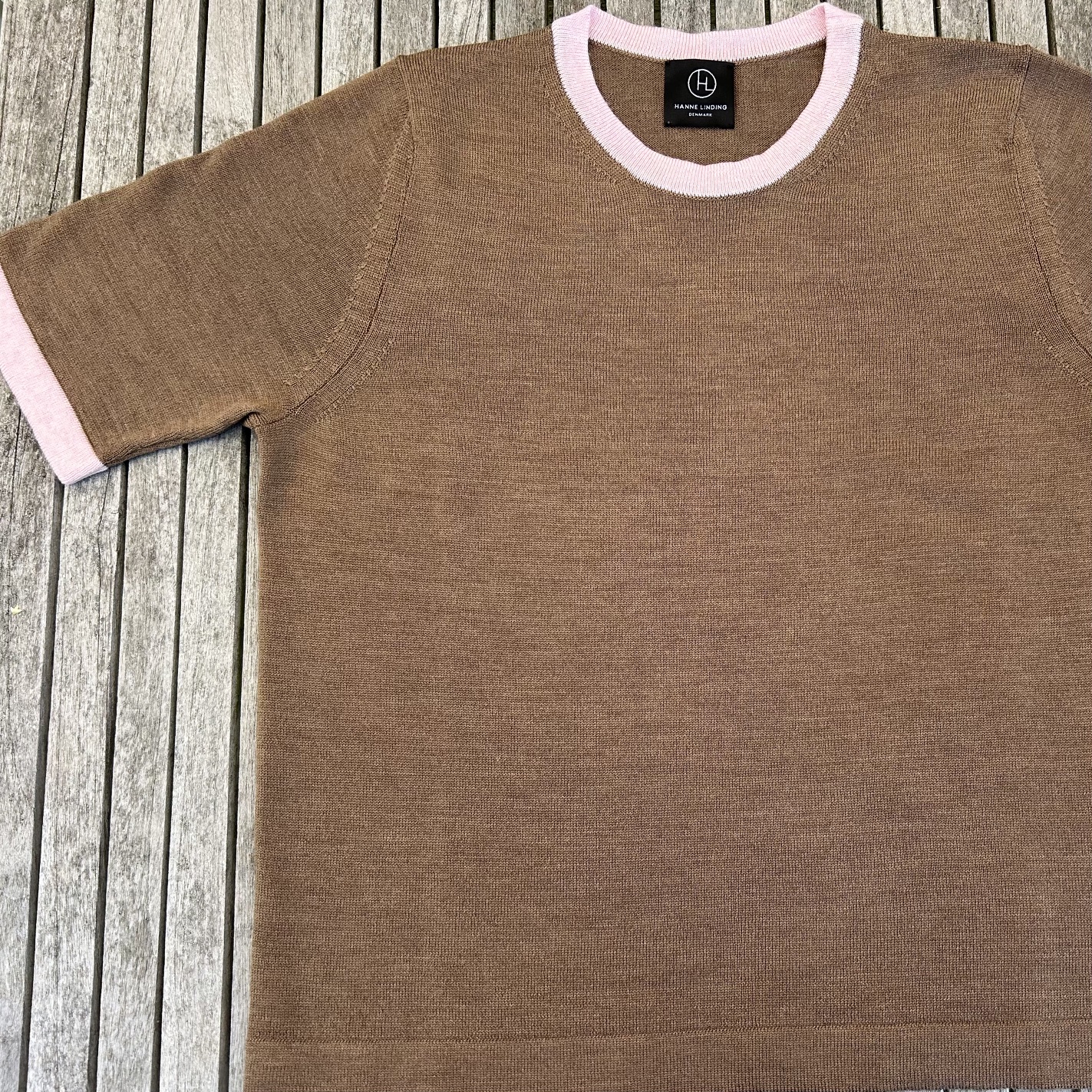 Brown knit blouse with pink edges and Hanne Linding logo.
